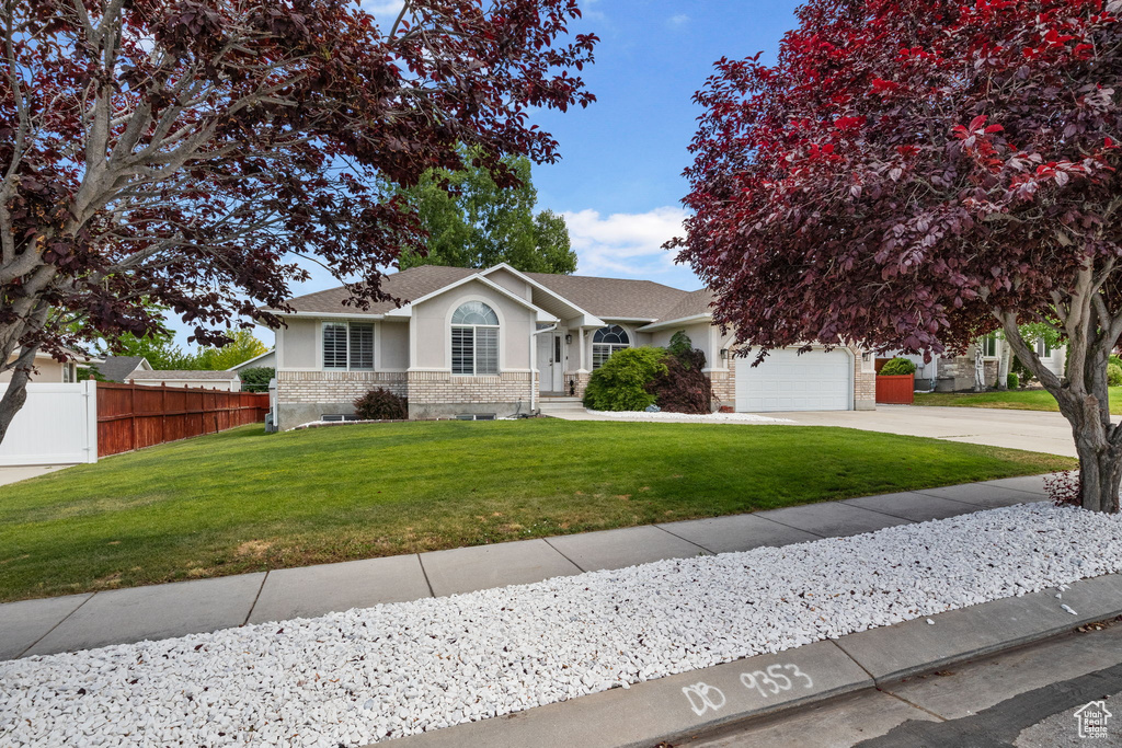 Ranch-style home featuring stucco siding, driveway, a garage, and roof with shingles