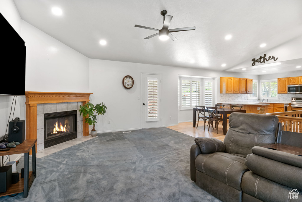 Living area featuring lofted ceiling, recessed lighting, ceiling fan, and a fireplace
