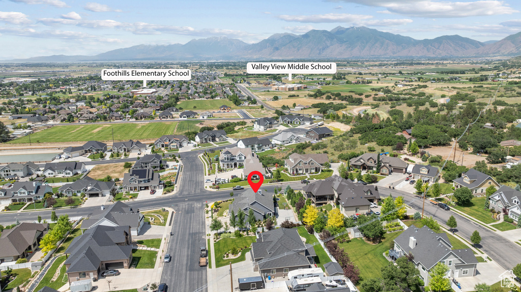 Aerial view of property and surrounding area with mountains and nearby suburban area