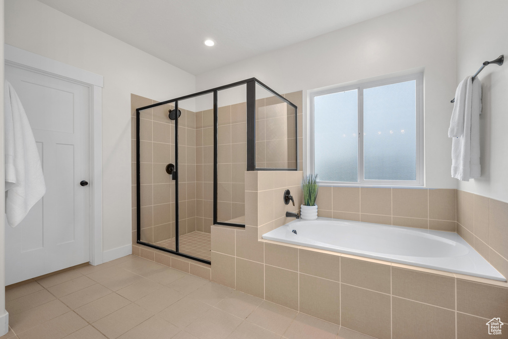 Full bathroom featuring a garden tub, a shower stall, and tile patterned floors