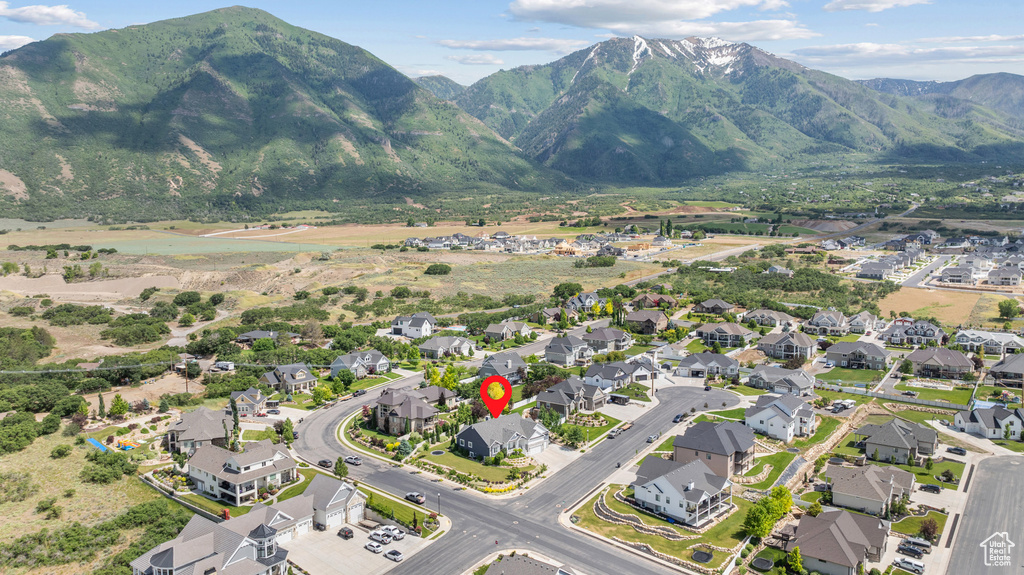 Aerial view of property and surrounding area with a mountain backdrop and nearby suburban area