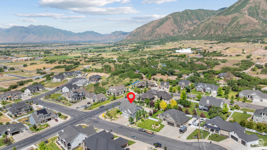 Aerial view of property and surrounding area featuring a mountain backdrop and nearby suburban area