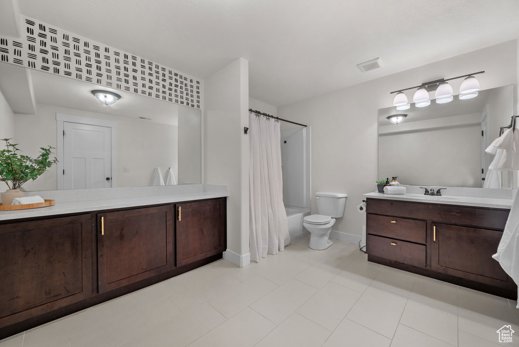 Full bath featuring vanity, shower / tub combo, and tile patterned floors