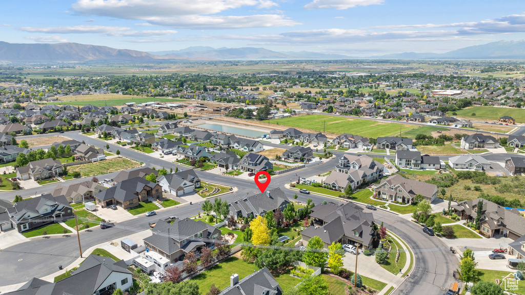 Aerial overview of property\'s location featuring nearby suburban area and a mountainous background