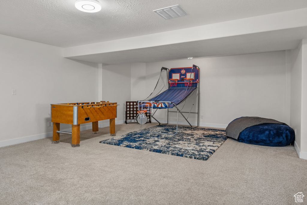 Playroom with carpet and a textured ceiling