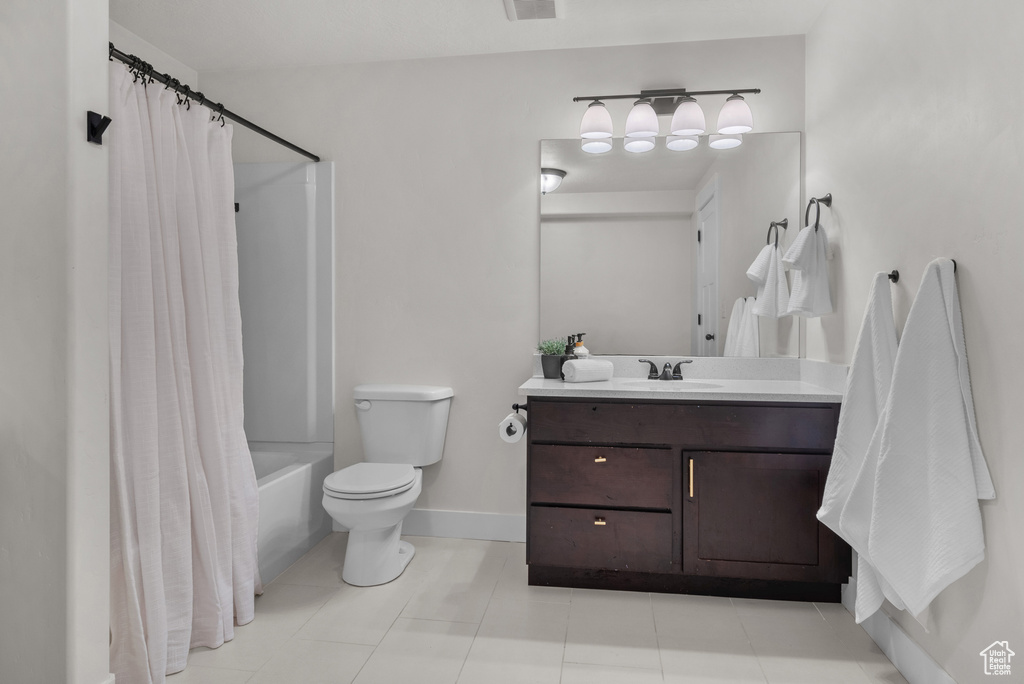 Bathroom with vanity, shower / bath combo, and tile patterned flooring