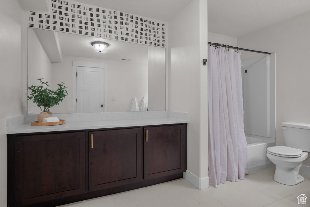 Full bathroom featuring vanity, shower / bath combo, and tile patterned flooring