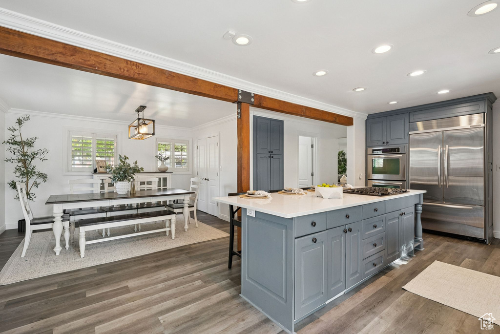 Kitchen featuring appliances with stainless steel finishes, gray cabinets, crown molding, dark wood-style flooring, and light countertops