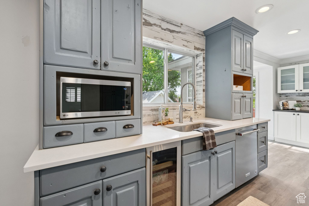 Kitchen featuring gray cabinetry, beverage cooler, stainless steel appliances, tasteful backsplash, and recessed lighting