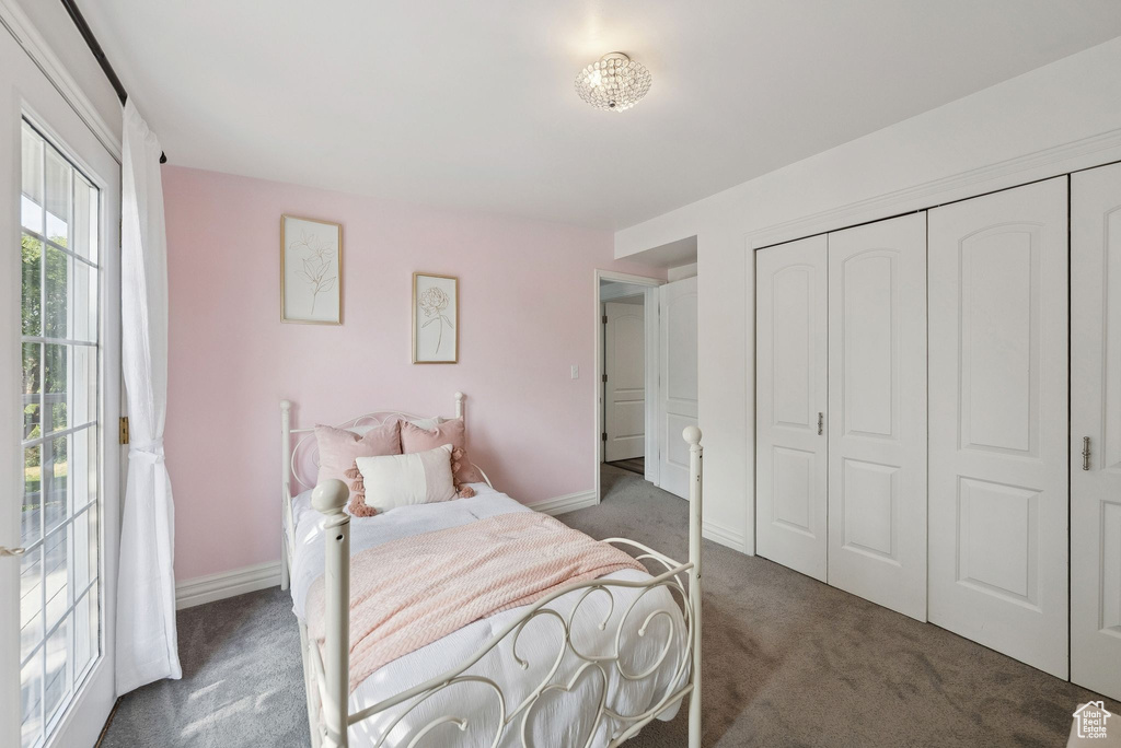 Carpeted bedroom with baseboards and a closet