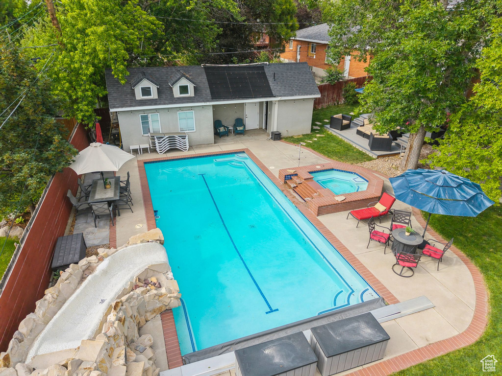 View of swimming pool with an in-ground hot tub, an outdoor structure, a patio area, an outdoor living space, and an exterior structure