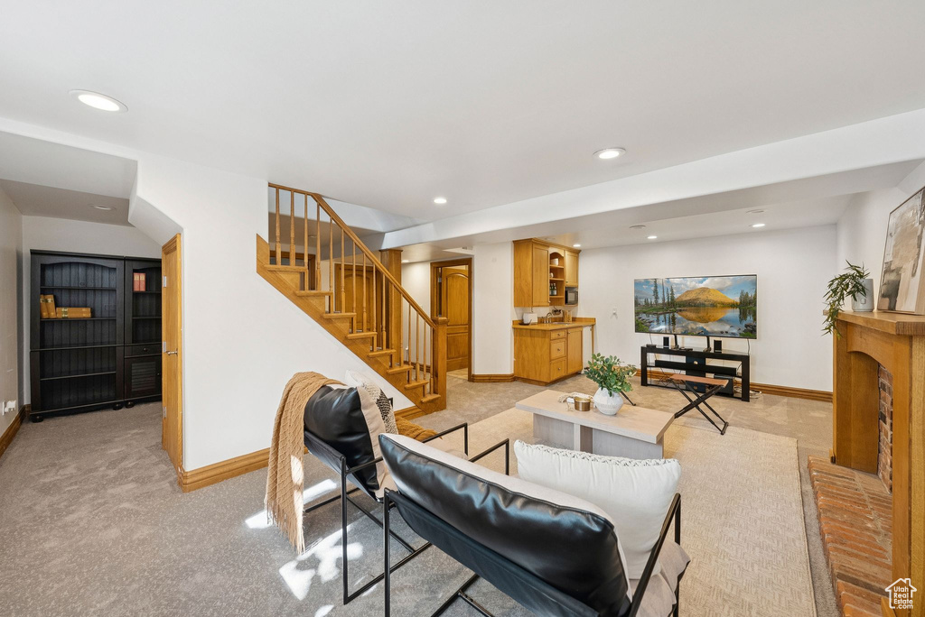 Living area with recessed lighting, stairs, a fireplace, and light colored carpet