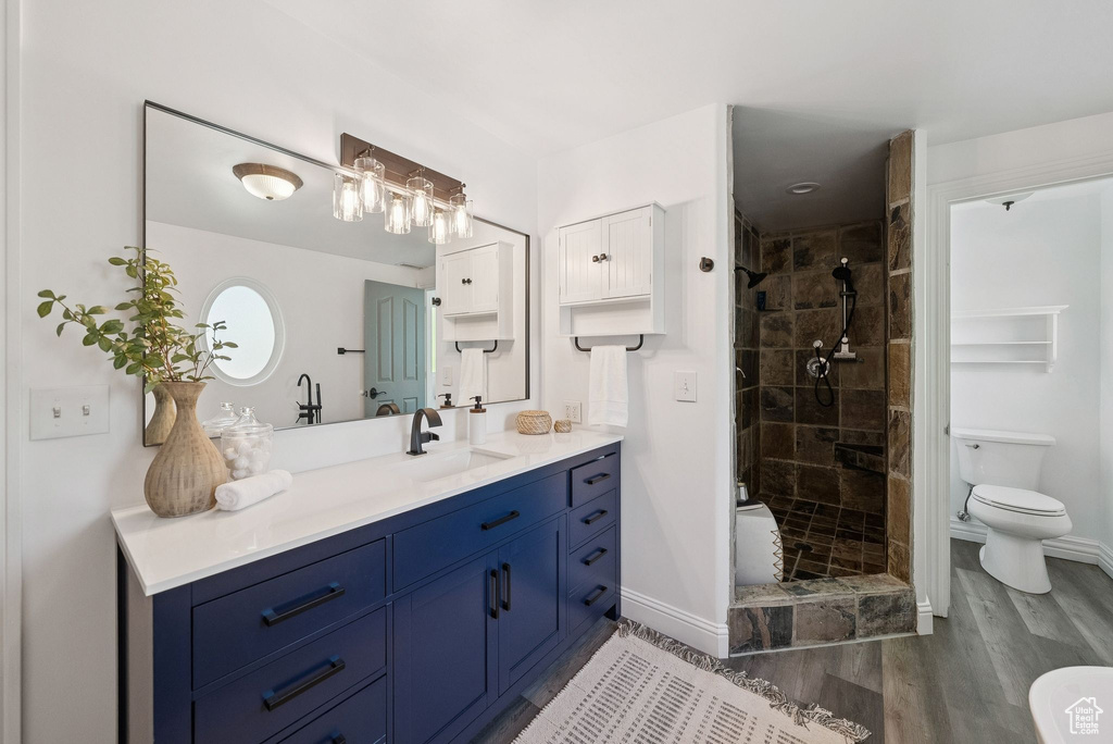 Full bathroom with vanity, a shower stall, and wood finished floors