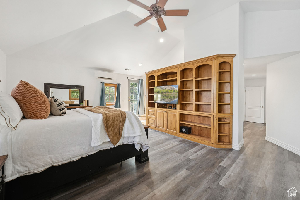 Bedroom featuring a wall mounted air conditioner, access to outside, high vaulted ceiling, recessed lighting, and wood finished floors