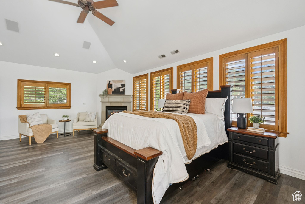 Bedroom with lofted ceiling, wood finished floors, a glass covered fireplace, recessed lighting, and ceiling fan