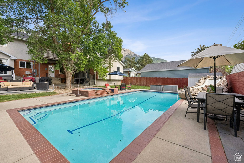 View of swimming pool featuring an in-ground hot tub, an outdoor living space, a patio area, and outdoor dining space