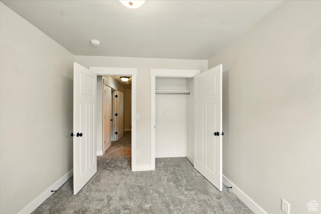 Unfurnished bedroom with carpet and a closet