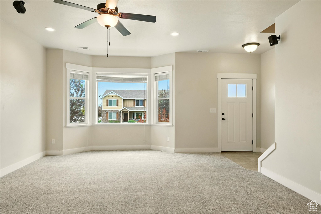 Carpeted entrance foyer featuring plenty of natural light, a ceiling fan, and recessed lighting