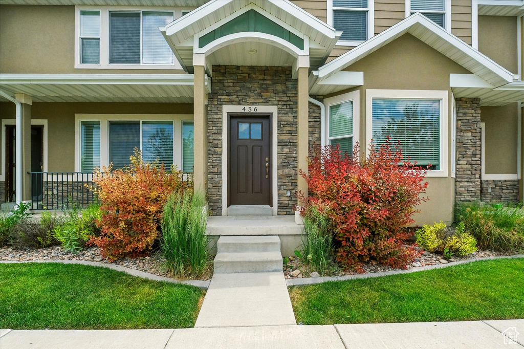 View of exterior entry featuring stone siding and stucco siding