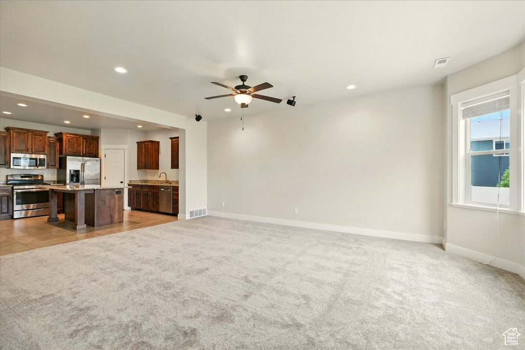 Unfurnished living room with light carpet, recessed lighting, and ceiling fan