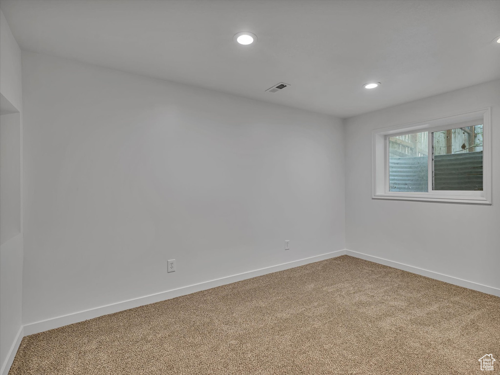 Carpeted spare room featuring baseboards and recessed lighting