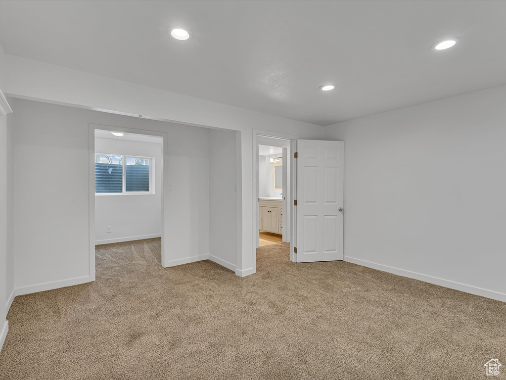 Unfurnished bedroom featuring light carpet, recessed lighting, and ensuite bath