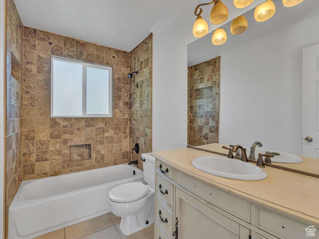 Bathroom featuring vanity, tile patterned floors, shower / tub combination, and ornamental molding