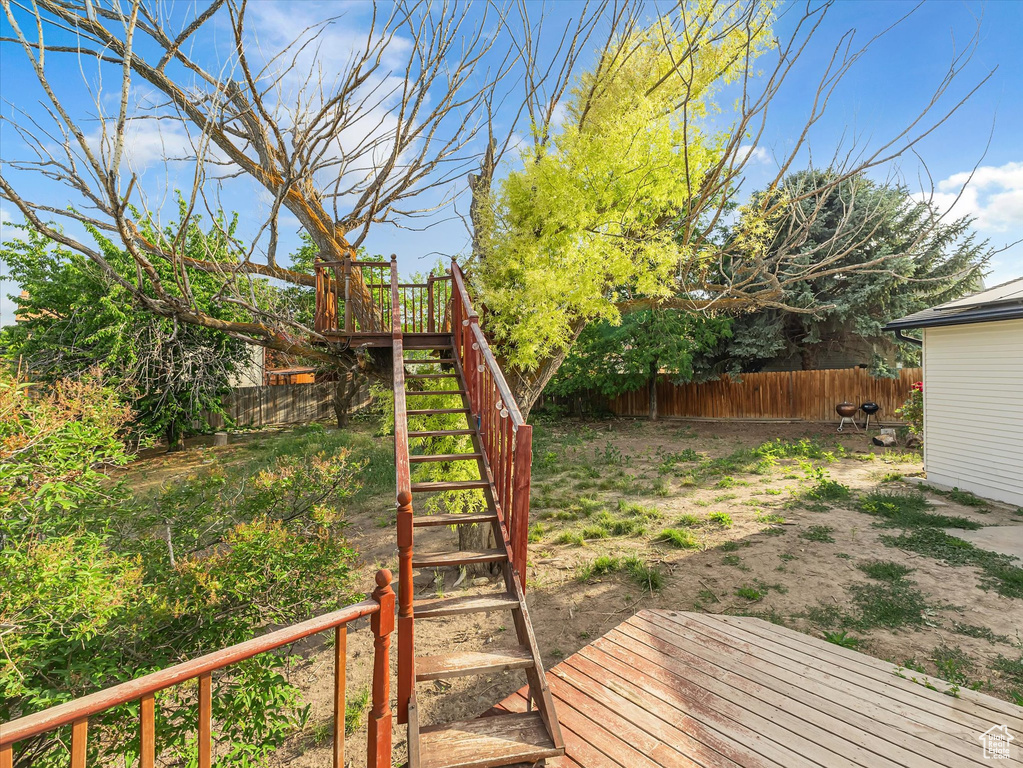 Fenced backyard with stairway and a deck