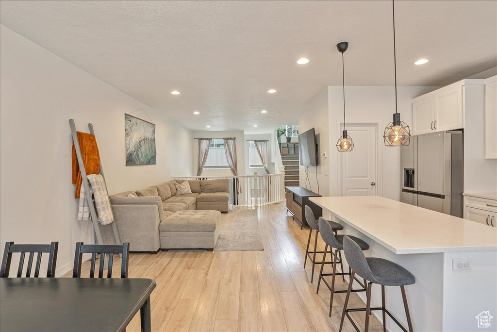 Dining area featuring light wood-style flooring, stairs, and recessed lighting