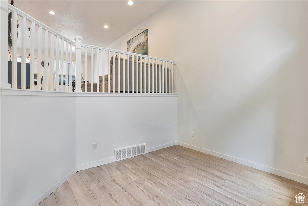 Staircase featuring wood finished floors and recessed lighting