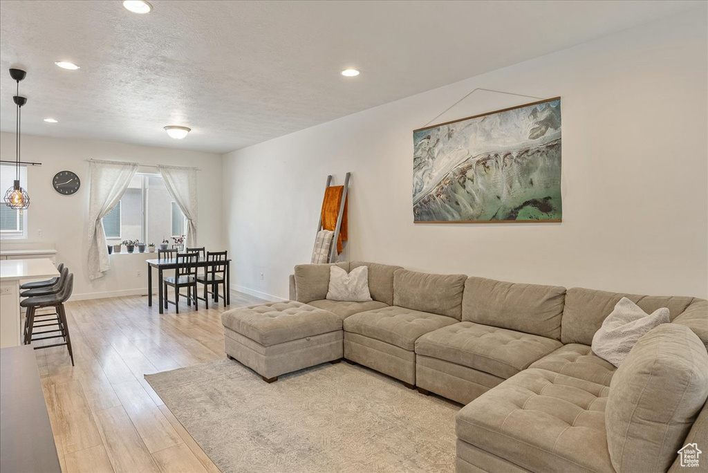 Living area with recessed lighting, light wood-type flooring, and a textured ceiling