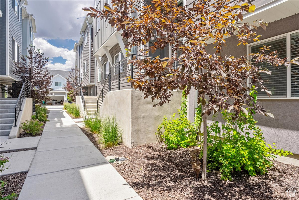 View of side of property featuring stairway, stucco siding, and a residential view
