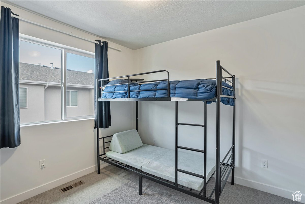 Bedroom with carpet floors and a textured ceiling
