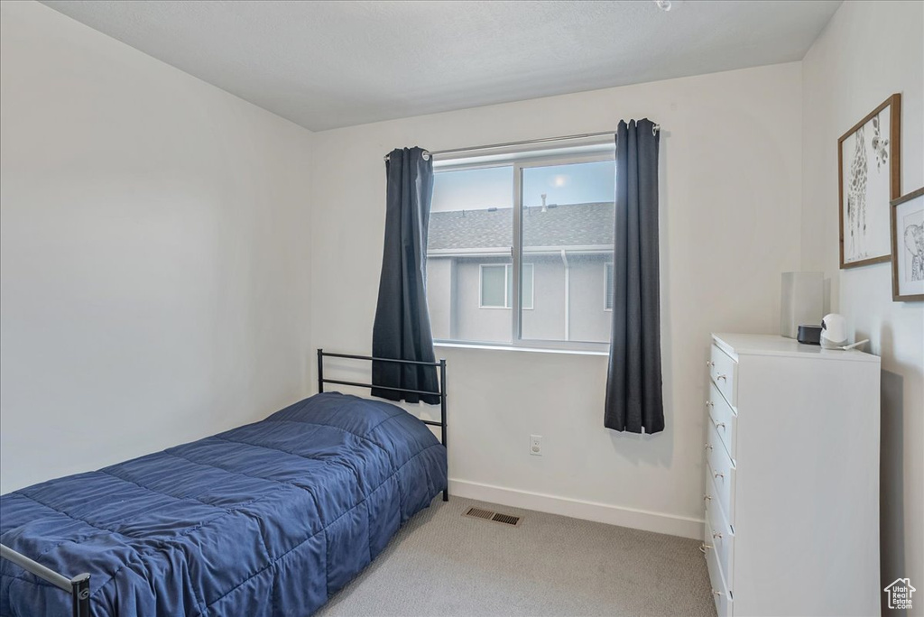 Bedroom with baseboards and light carpet