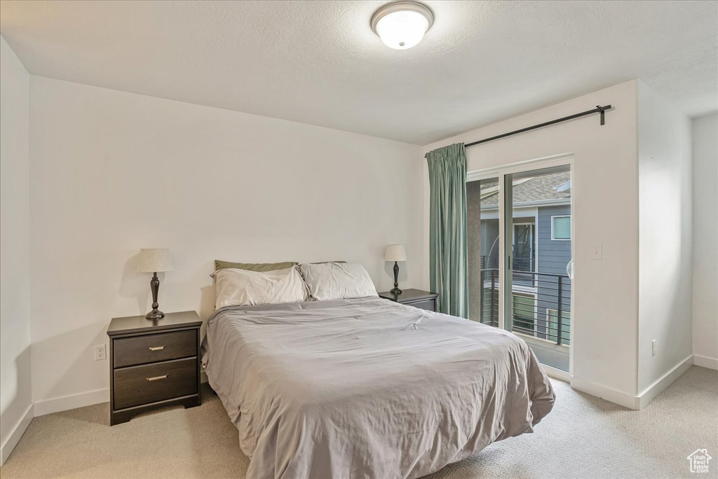 Bedroom featuring access to exterior and light colored carpet