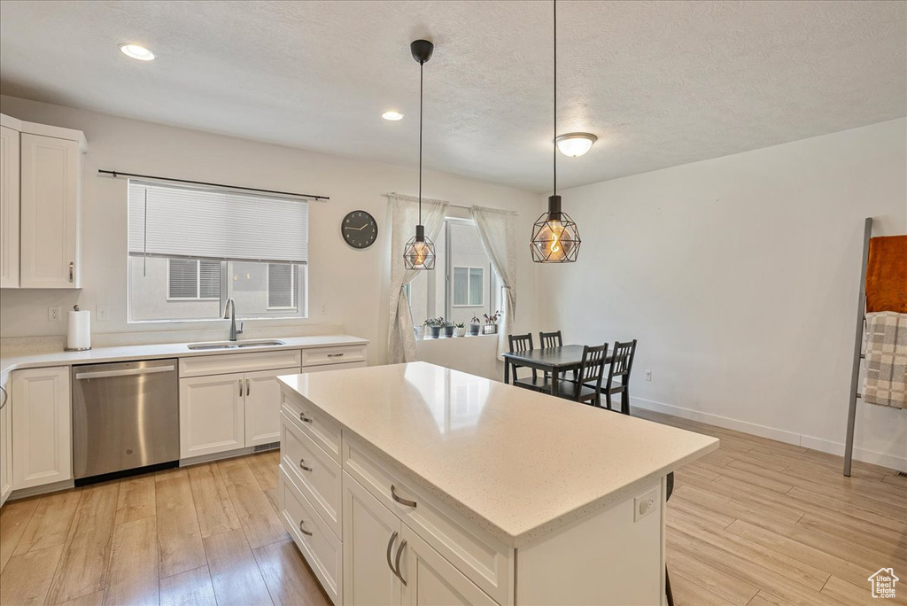 Kitchen featuring dishwasher, light wood-style floors, light countertops, white cabinetry, and recessed lighting