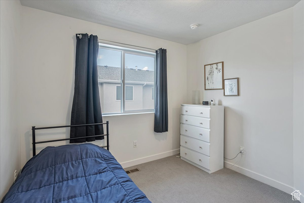 Bedroom with baseboards and light colored carpet