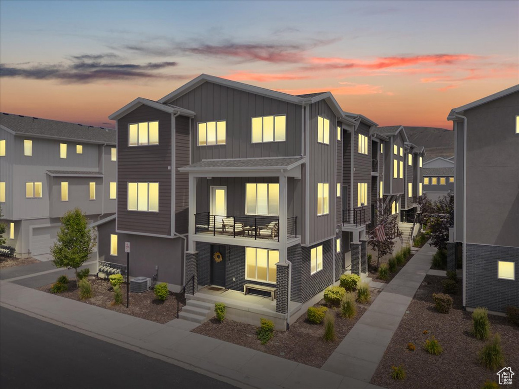 Townhome / multi-family property with board and batten siding, a balcony, and a residential view