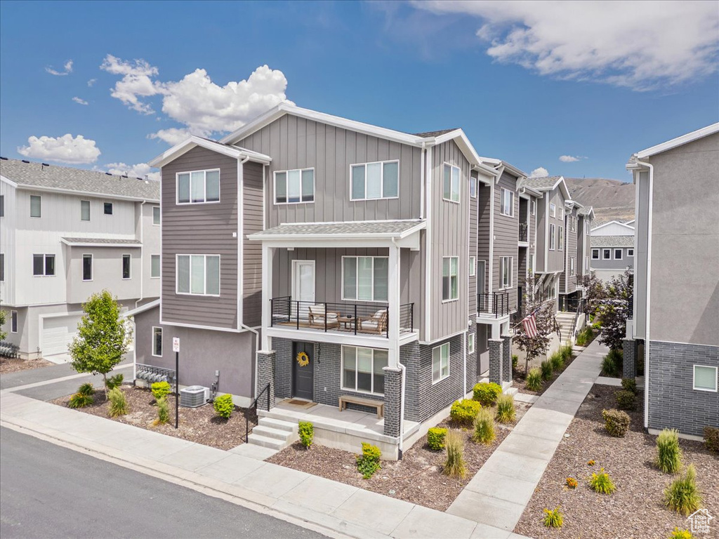 Multi unit property with board and batten siding, a balcony, and a residential view