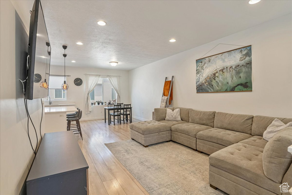 Living room featuring recessed lighting, light wood-type flooring, and a textured ceiling