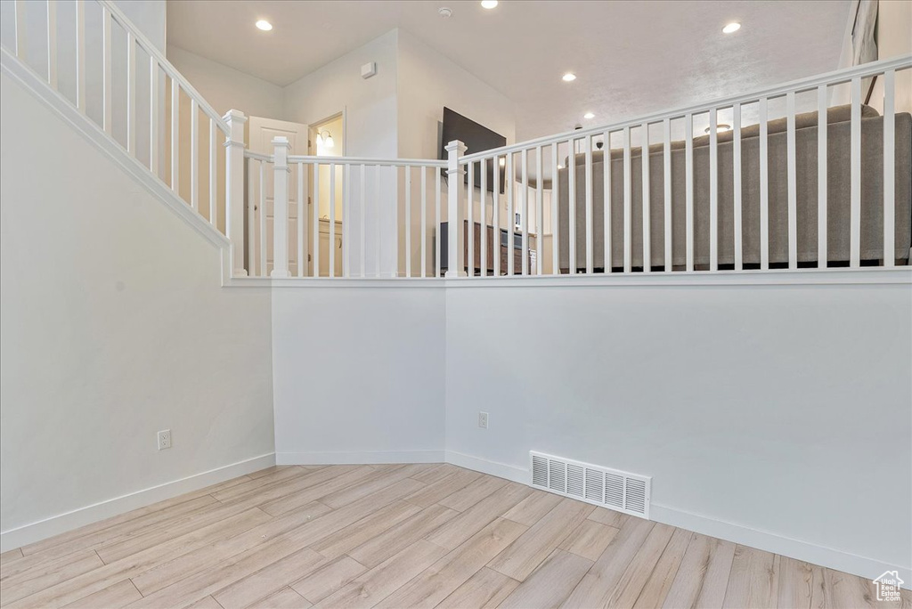 Stairway with wood finished floors and recessed lighting