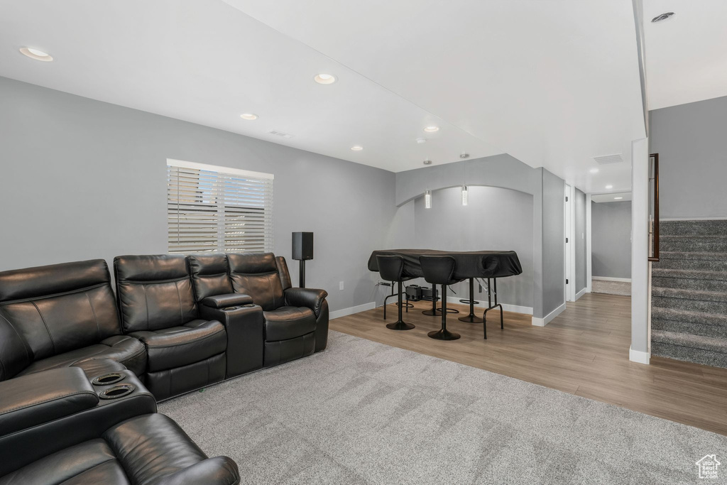 Living room with wood finished floors, recessed lighting, stairway, baseboards, and arched walkways