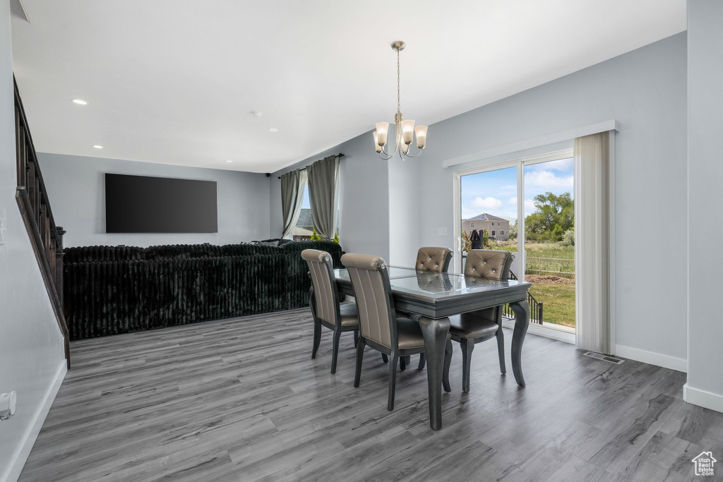 Dining space with a chandelier, wood finished floors, baseboards, and recessed lighting