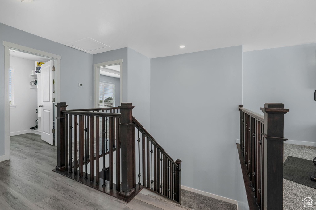 Stairway with baseboards, attic access, and wood finished floors