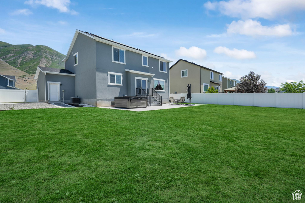 Back of property featuring a patio, central AC, and stucco siding