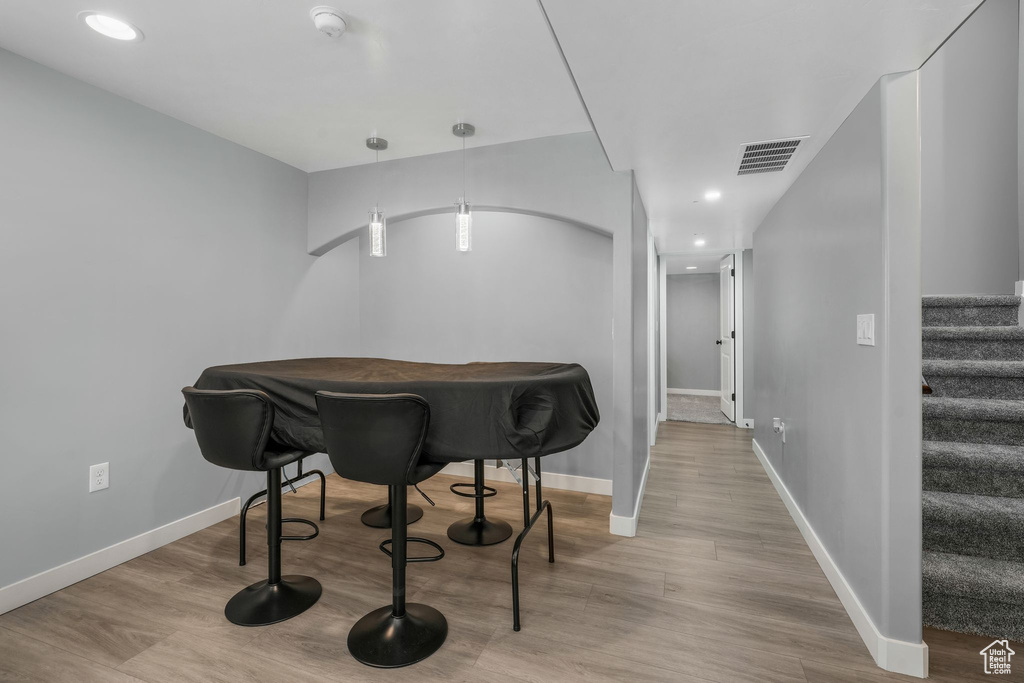 Dining space featuring wood finished floors, stairs, baseboards, and recessed lighting