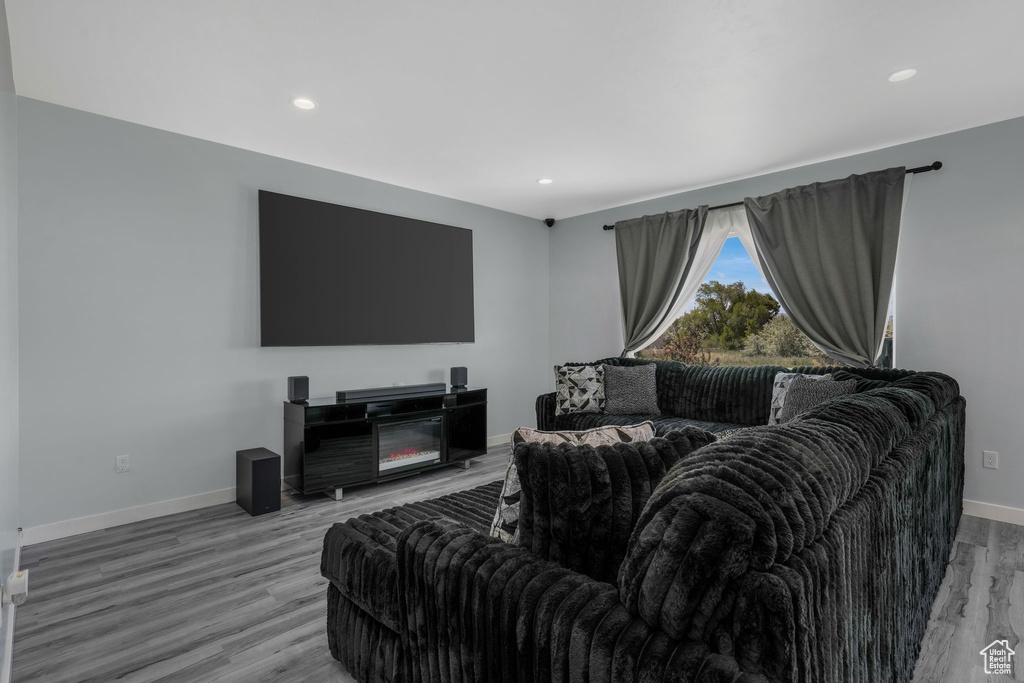 Living area featuring baseboards, light wood-style floors, and recessed lighting