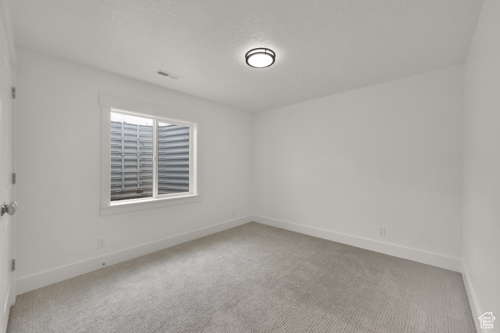 Empty room featuring carpet floors and a textured ceiling