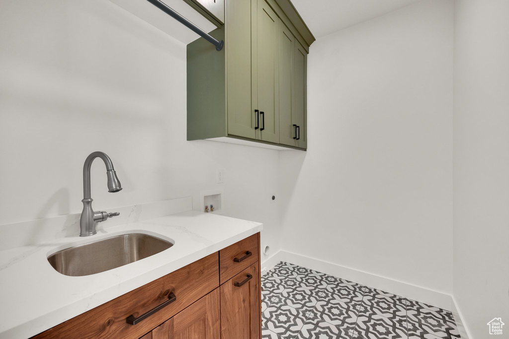 Washroom featuring hookup for an electric dryer, cabinet space, and hookup for a washing machine