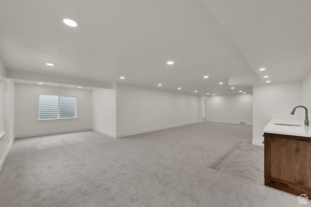 Below grade area featuring light colored carpet and recessed lighting